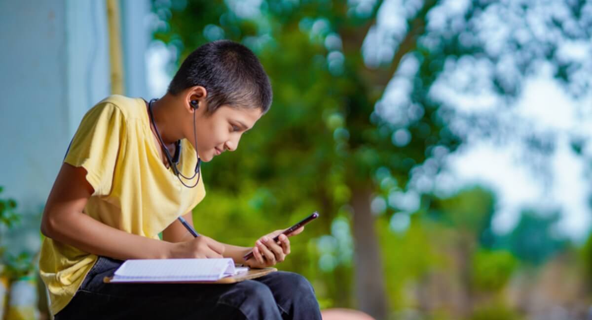 Boy receiving distance learning through a smartphone