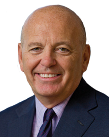 Paul J. Reilly headshot a man in a suit smiling
