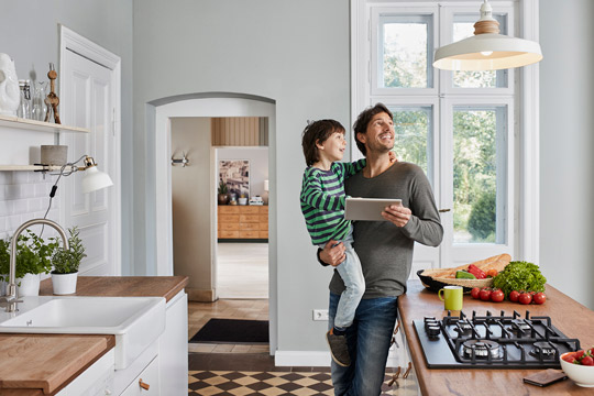 Connected Living Assurant Man turning on lights with connected device protected by Assurant