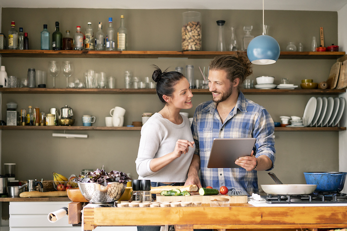 Couple looking at each other and using their tablet