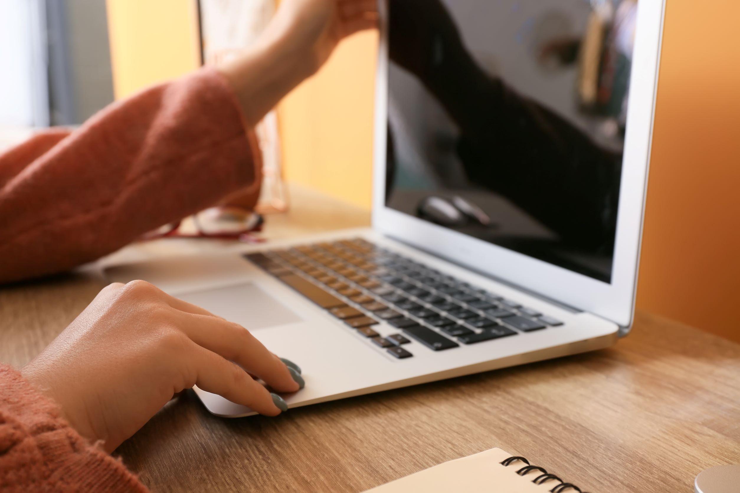 Close up of a woman's hand opening up her laptop