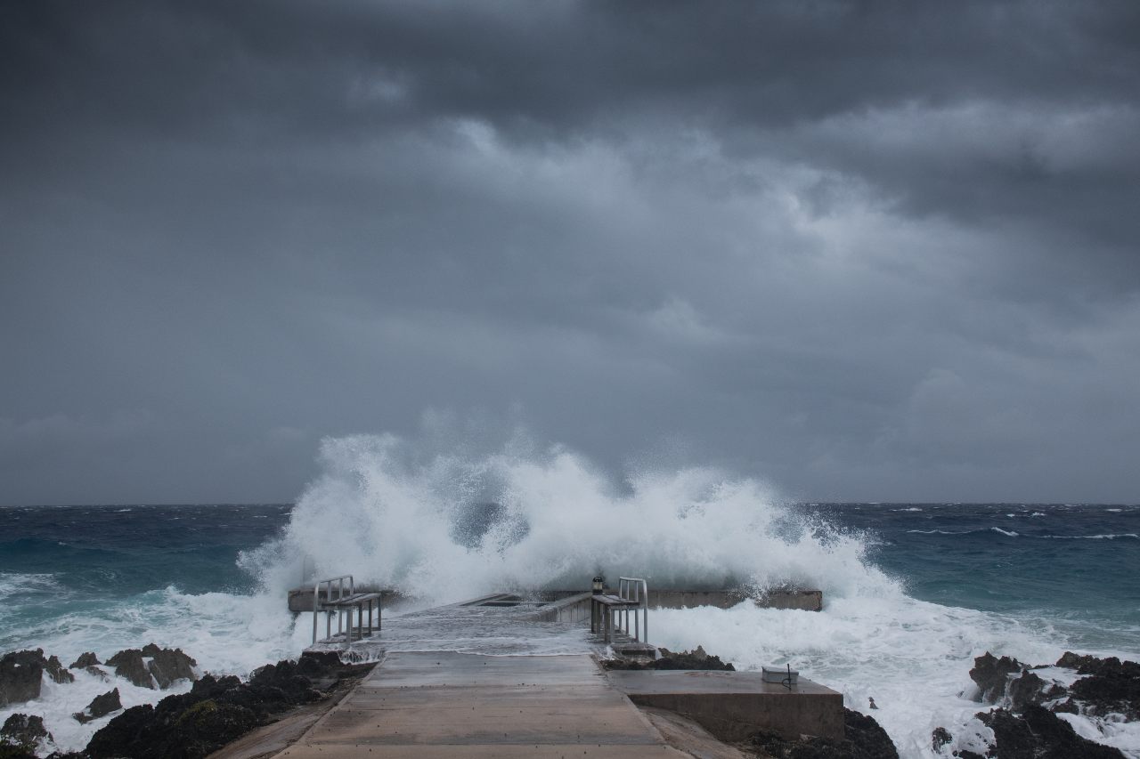 Hurricane at a beach with waves crashing onto a dock