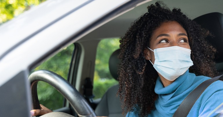 Woman test driving car with mask on
