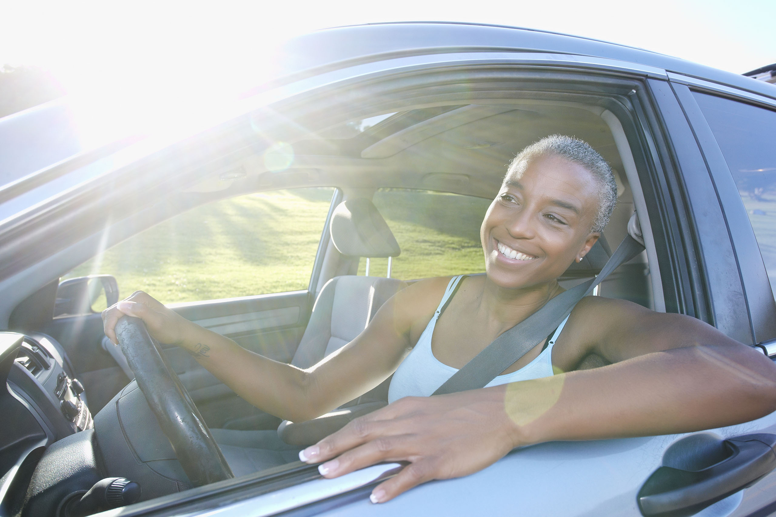 VehicleServiceContract Woman driving with and smiling while looking out the car window