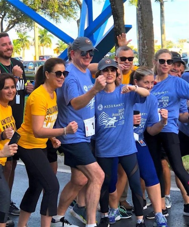 5k Race Assurant CEO Alan Colberg posing with employees at the finish line of a 5K race