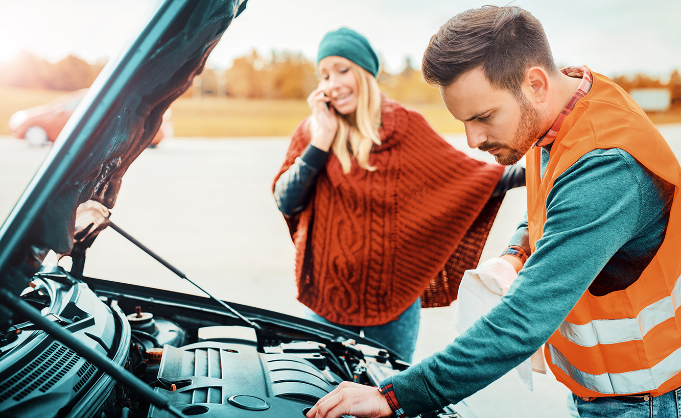 VPS-Roadside Assist-iS-626782286-LR Woman talking on the phone while mechanic examines her car